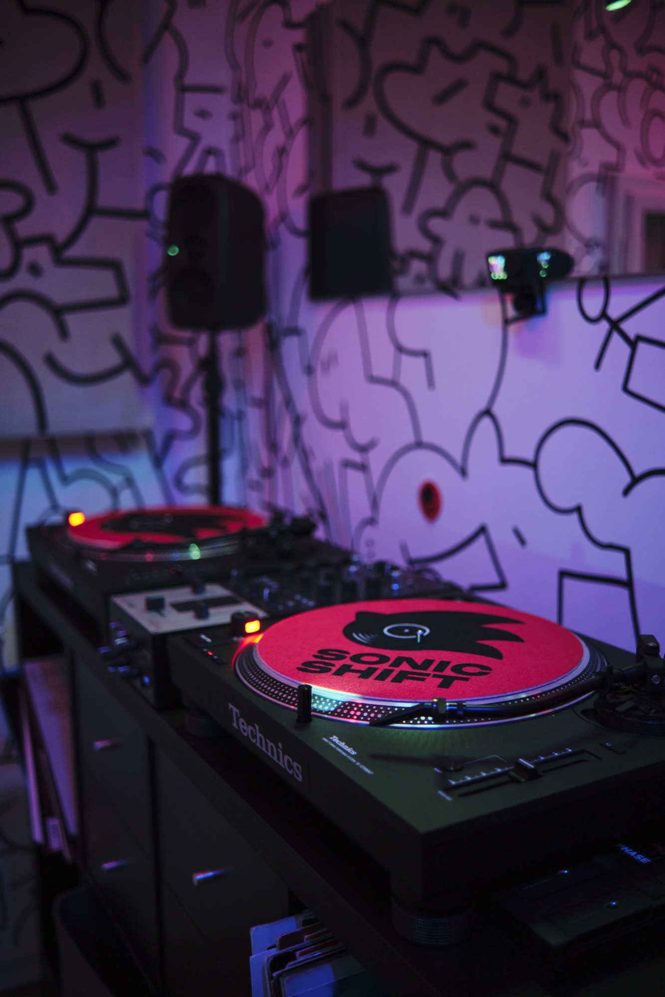 the booth — two Technics decks, Sonic Shift slipmats, doodle walls